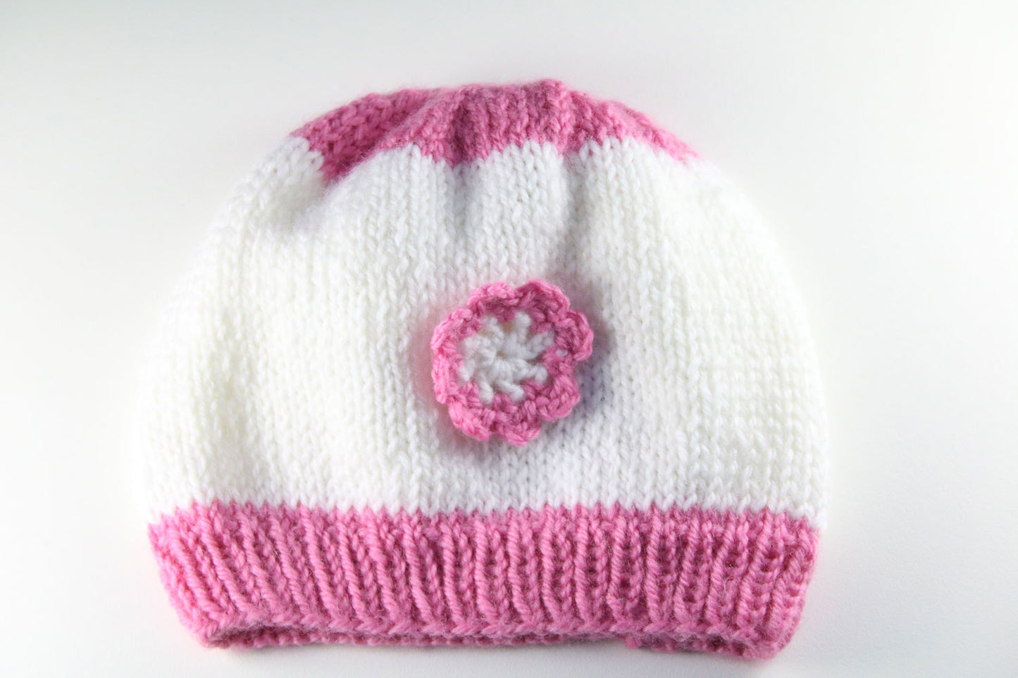 Rosa-weiße Babymütze mit Blümchen